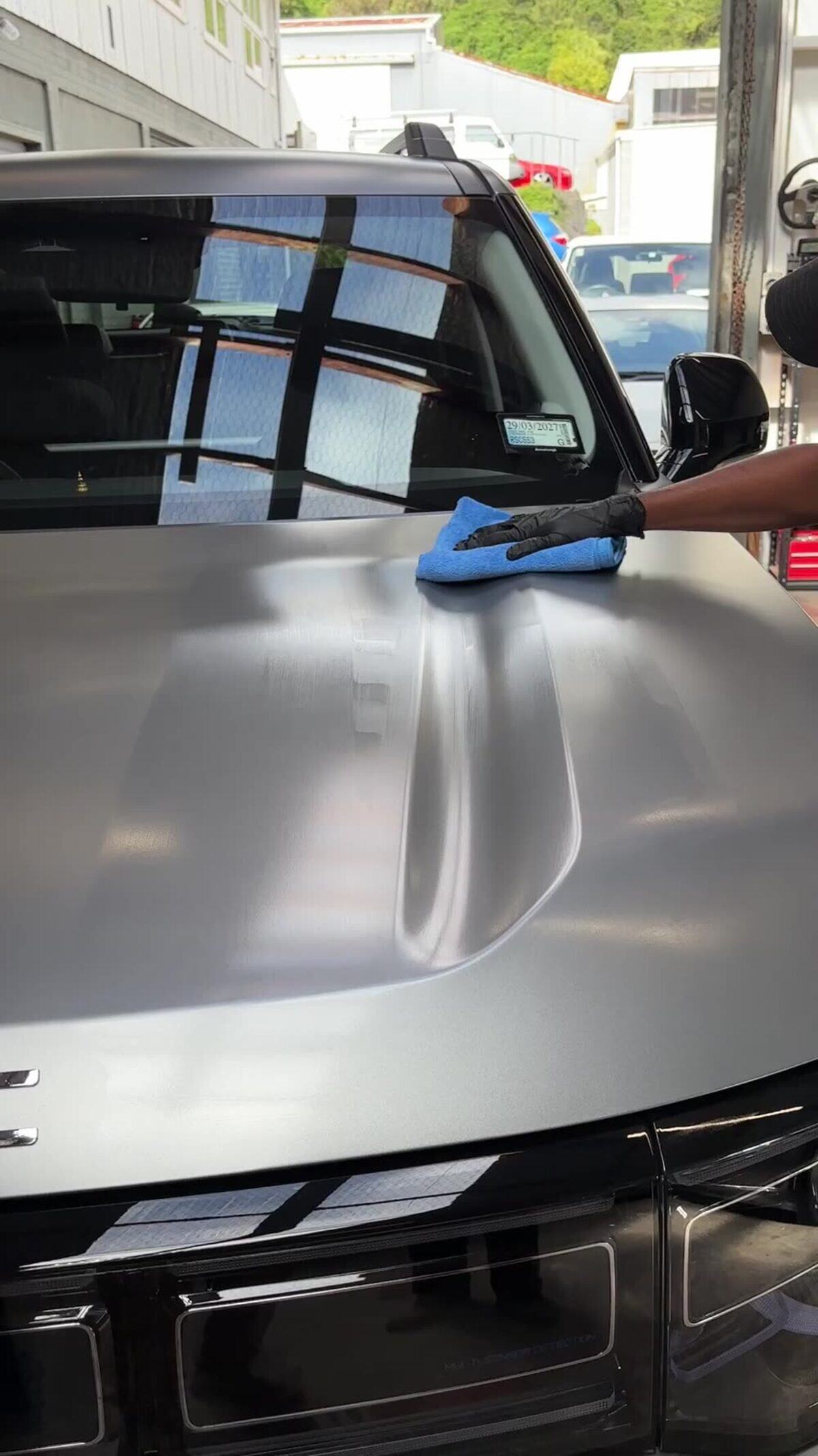 Levelling a fresh ceramic coating off a bonnet with a microfibre towel