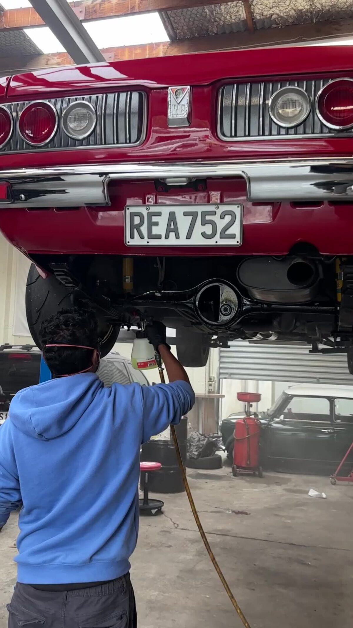 A classic coupe up on the hoist for an underbody and engine-bay clean